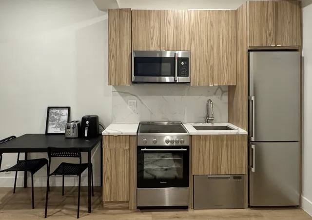 a kitchen with stainless steel appliances a stove microwave and refrigerator