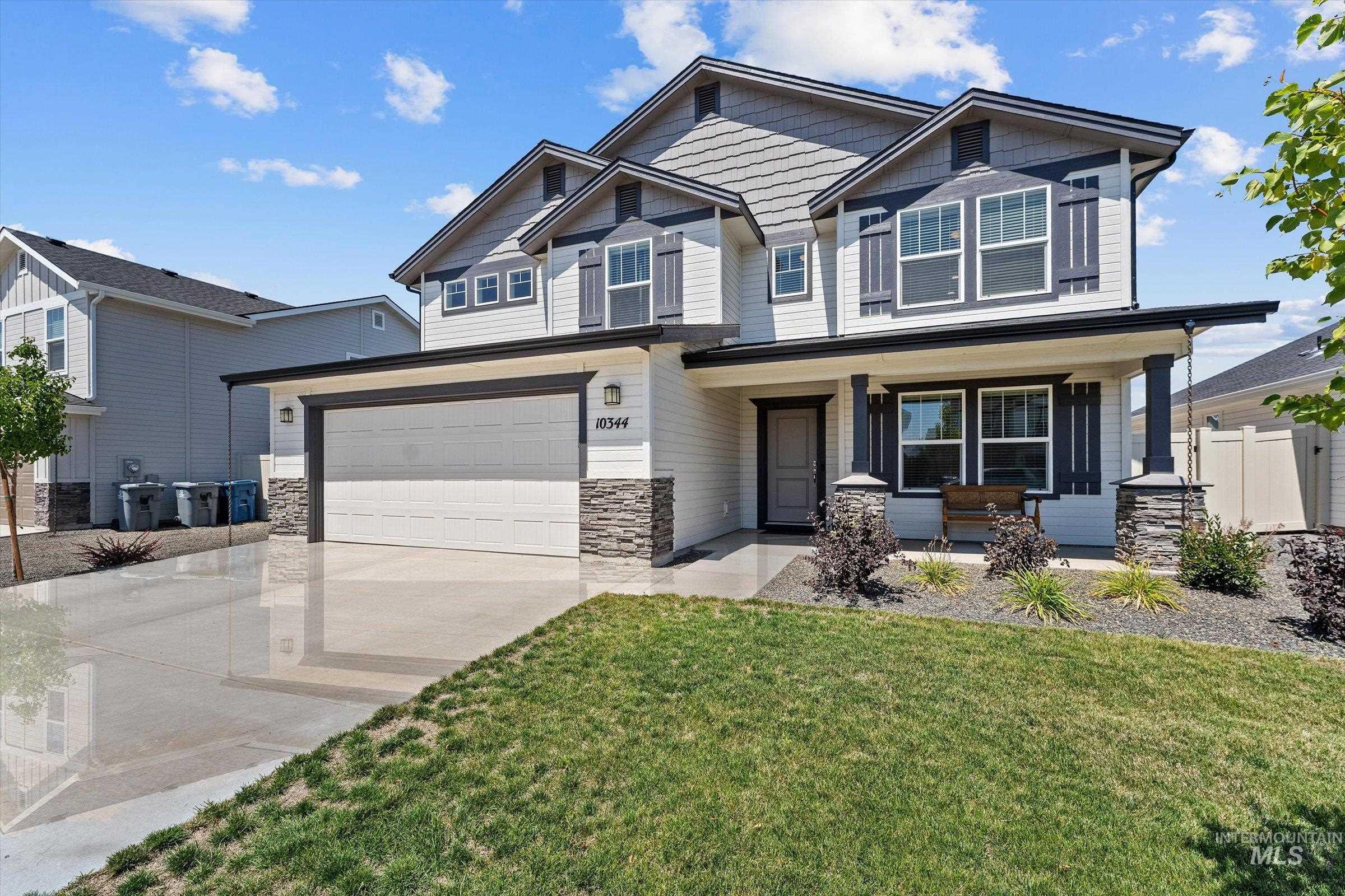 10344 Rockaway Ridge Street Nampa, ID 83687 - Photo 1 of 1 Craftsman-style house featuring covered porch, driveway, a garage, and stone siding