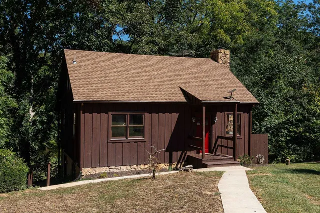 a view of a wooden house with large trees and large tree