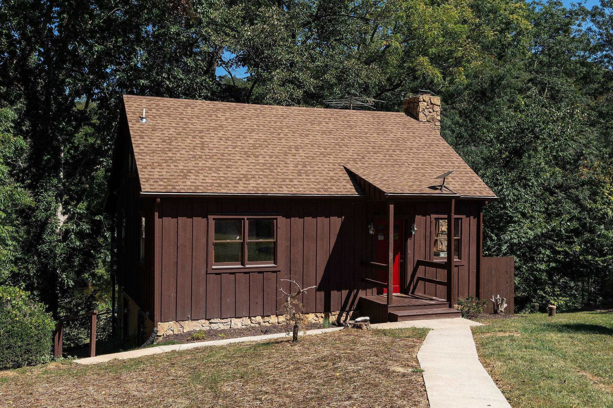 a view of a wooden house with large trees and large tree