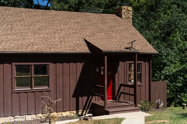a view of a house with backyard and tree