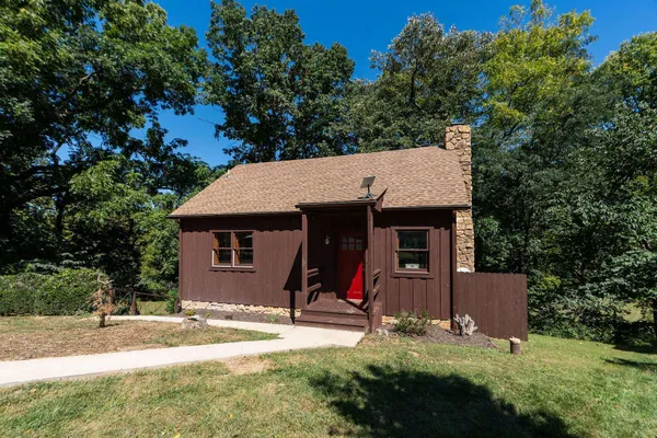 a view of a house with backyard and trees