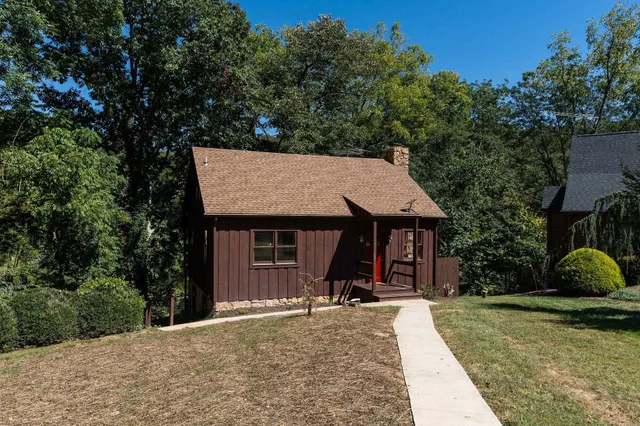 a view of a house with backyard and trees
