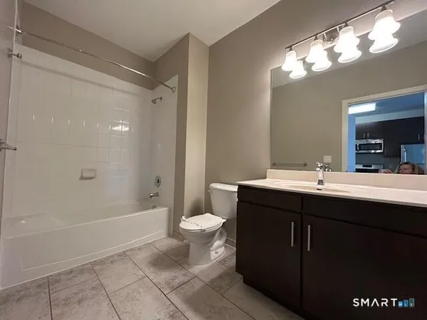 a bathroom with a sink a toilet a mirror and shower