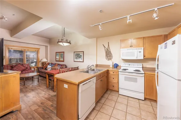 a kitchen that has a lot of white cabinets and stainless steel appliances