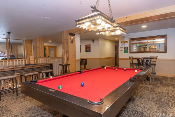 a room with furniture pool table and chairs