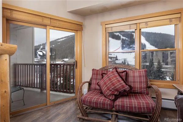 a living room with furniture a large window and wooden floor
