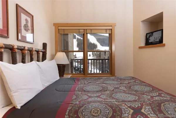 a large bed sitting in a bedroom next to a window