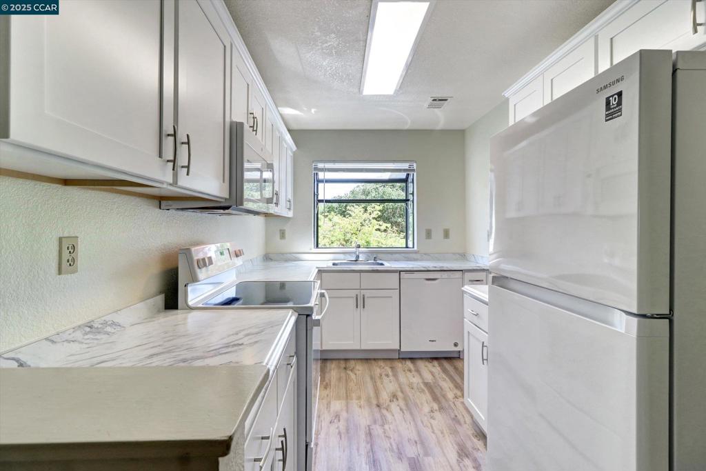 1300 Walden Road Walnut Creek, CA 94597 - Photo 7 of 52 a kitchen with a sink a refrigerator and window