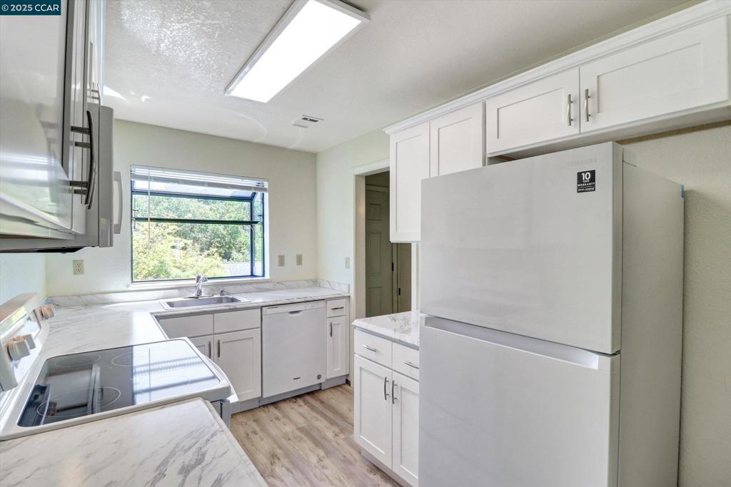 1300 Walden Road Walnut Creek, CA 94597 - Photo 8 of 52 a kitchen with white cabinets and white appliances