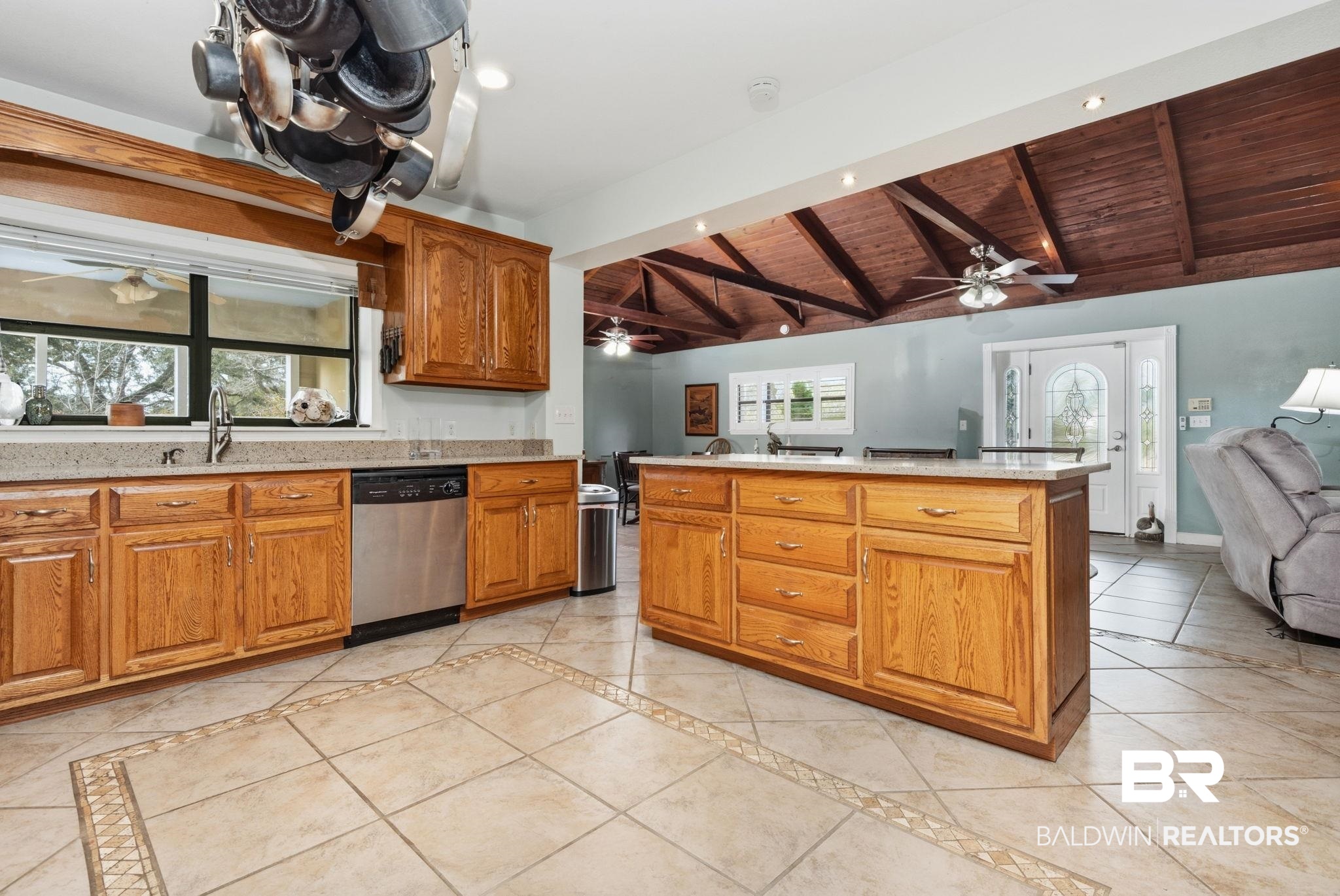 15025 Bellingrath Road Coden, AL 36523 - Photo 78 of 79 Kitchen with vaulted ceiling with beams, open floor plan, wood finish cabinetry, inlaid floor details, and dishwasher