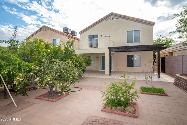 a front view of a house with a yard and potted plants