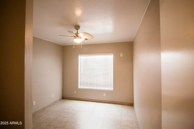 an empty room with windows and fan