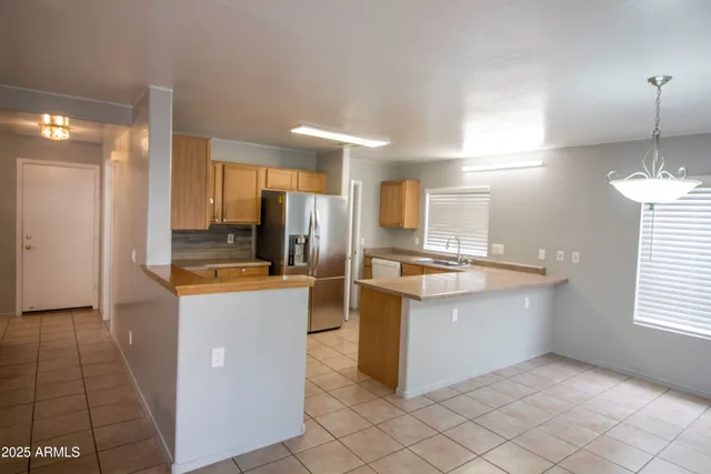 a kitchen with stainless steel appliances kitchen island granite countertop a refrigerator and a sink