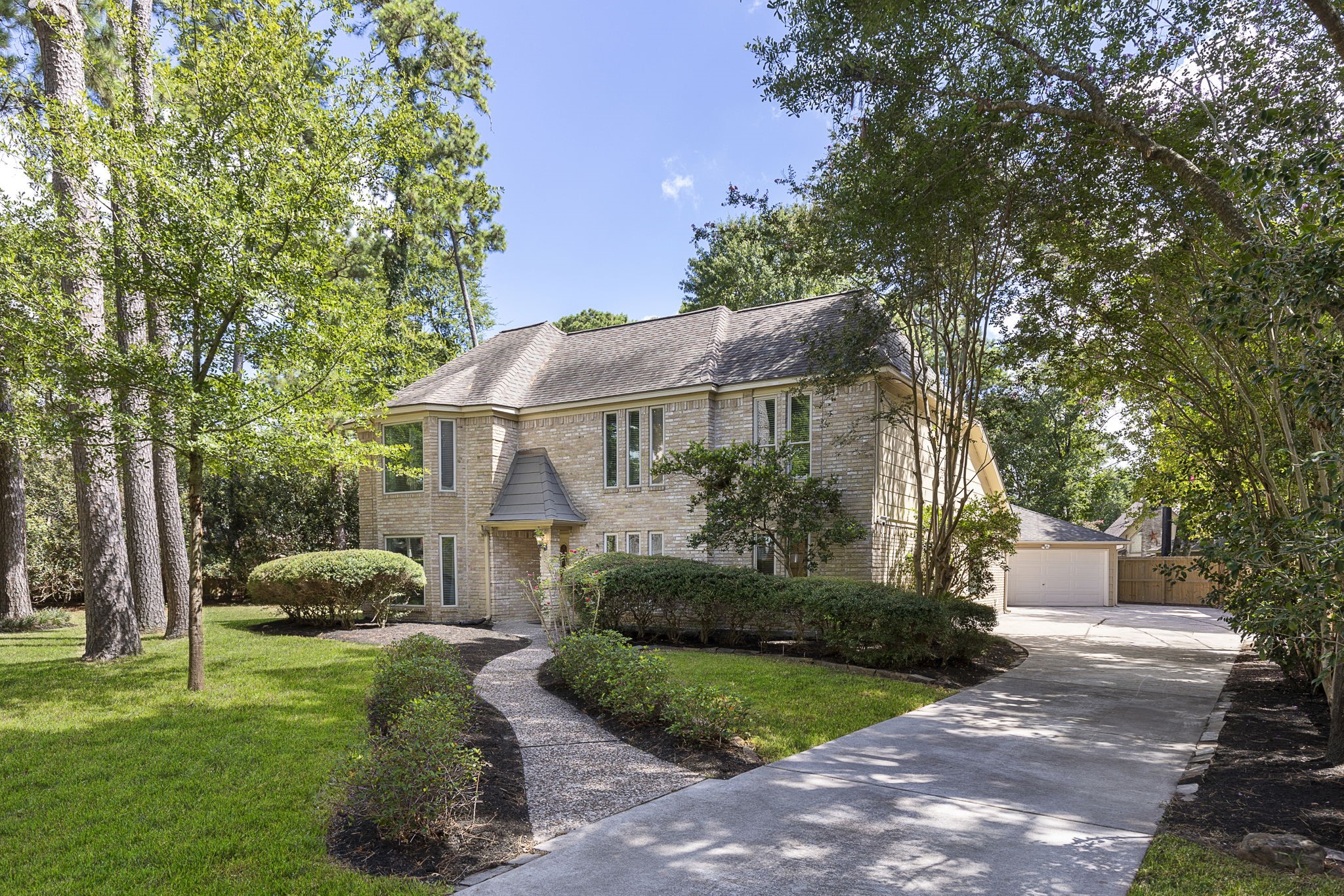 a front view of a house with a yard and trees