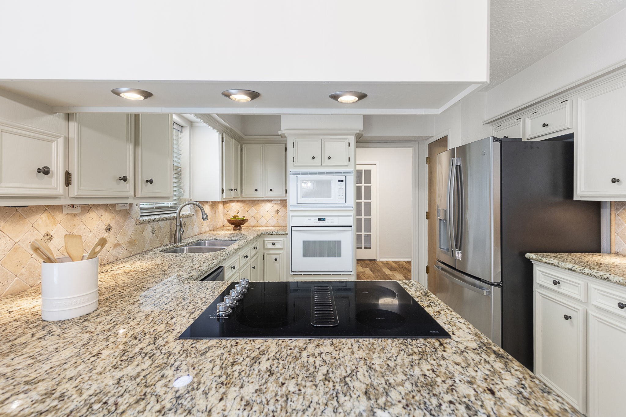 17706 Asphodel Lane Spring, TX 77379 - Photo 26 of 48 a kitchen with a refrigerator stove and white cabinets