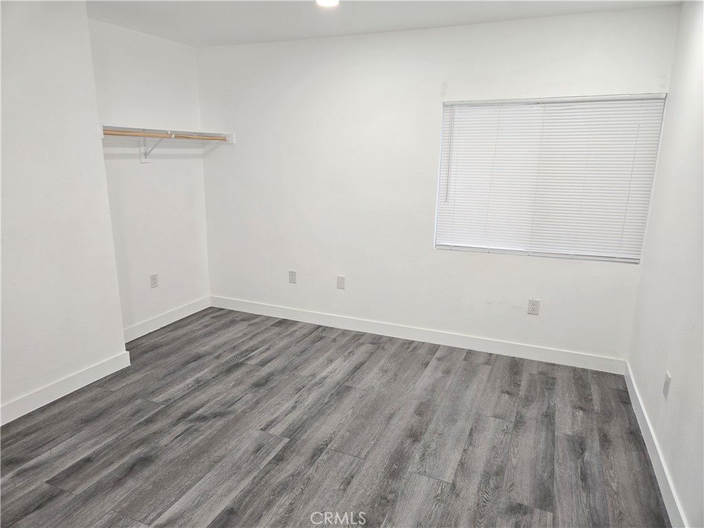5327 Tyler Street, Unit A Riverside, CA 92503 - Photo 6 of 8 an empty room with wooden floor and windows