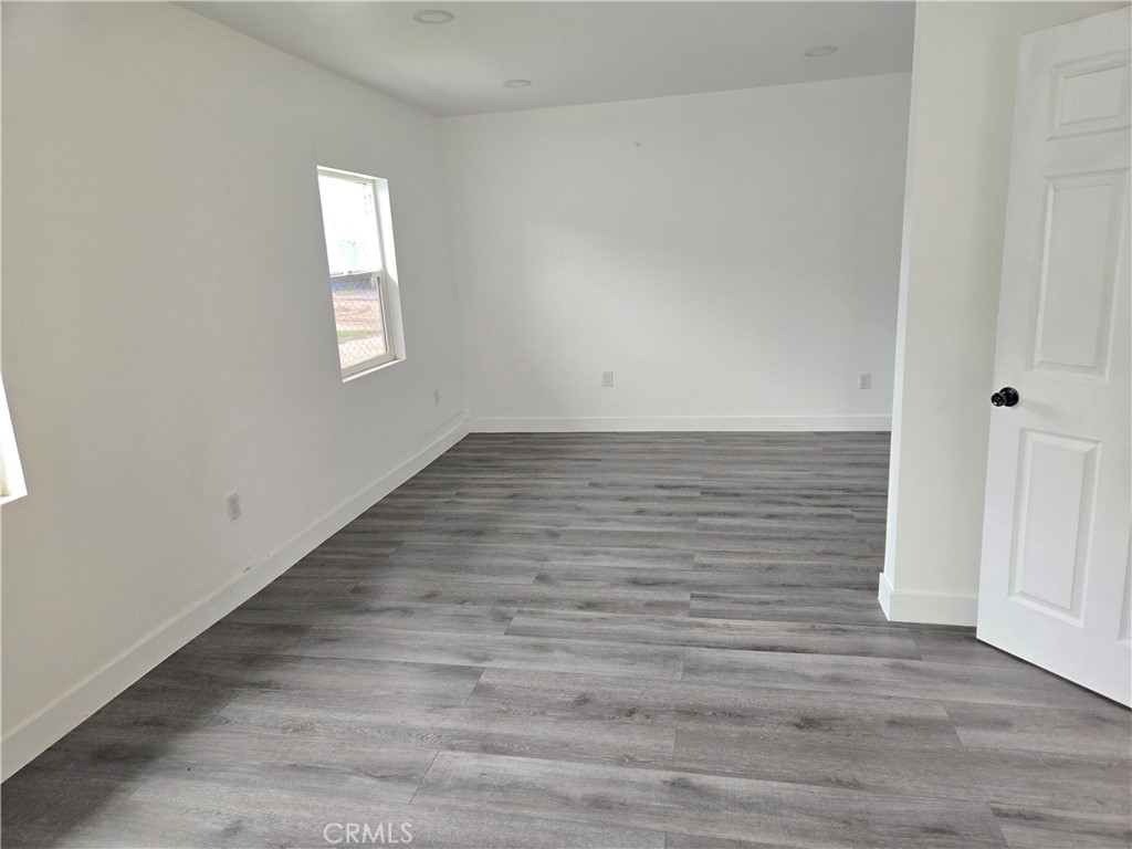 5327 Tyler Street, Unit A Riverside, CA 92503 - Photo 7 of 8 a view of an empty room with wooden floor and a window