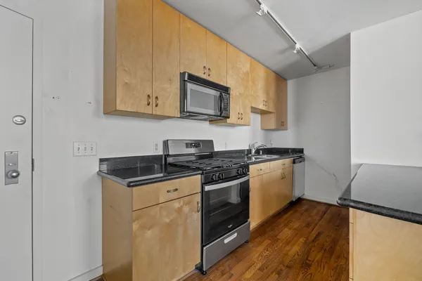 a kitchen with stainless steel appliances granite countertop a stove and a microwave