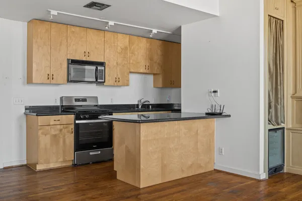 a kitchen with stainless steel appliances granite countertop a stove a sink and a refrigerator