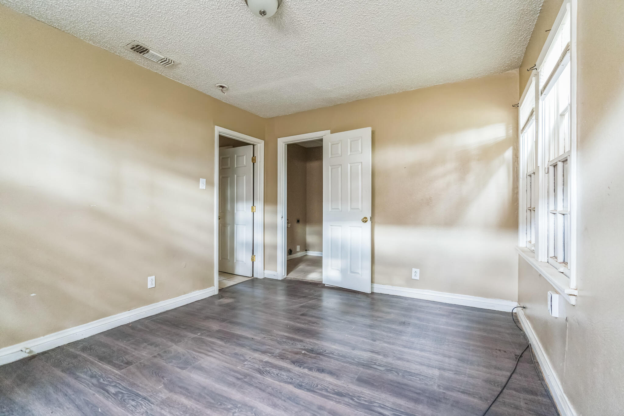1510 33rd Street Lubbock, TX 79411 - Photo 13 of 33 a view of an empty room with wooden floor and a window
