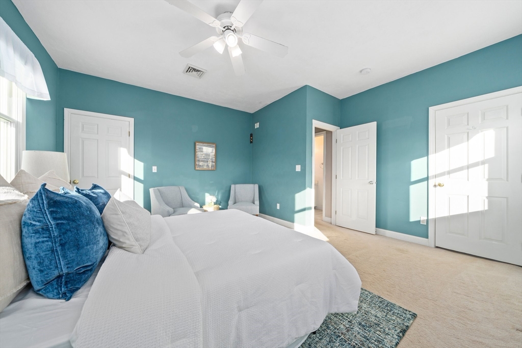 91 Prospect Street Canton, MA 02021 - Photo 20 of 41 a spacious bedroom with a large bed and a chandelier
