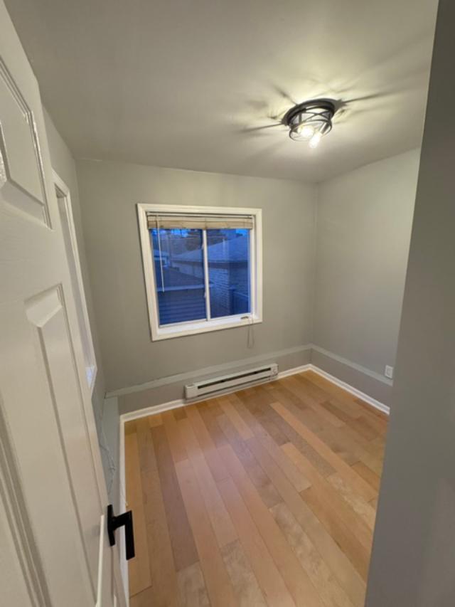 650 North Talman Avenue, Unit 1R Chicago, IL 60612 - Photo 2 of 5 a view of an empty room with wooden floor and a window