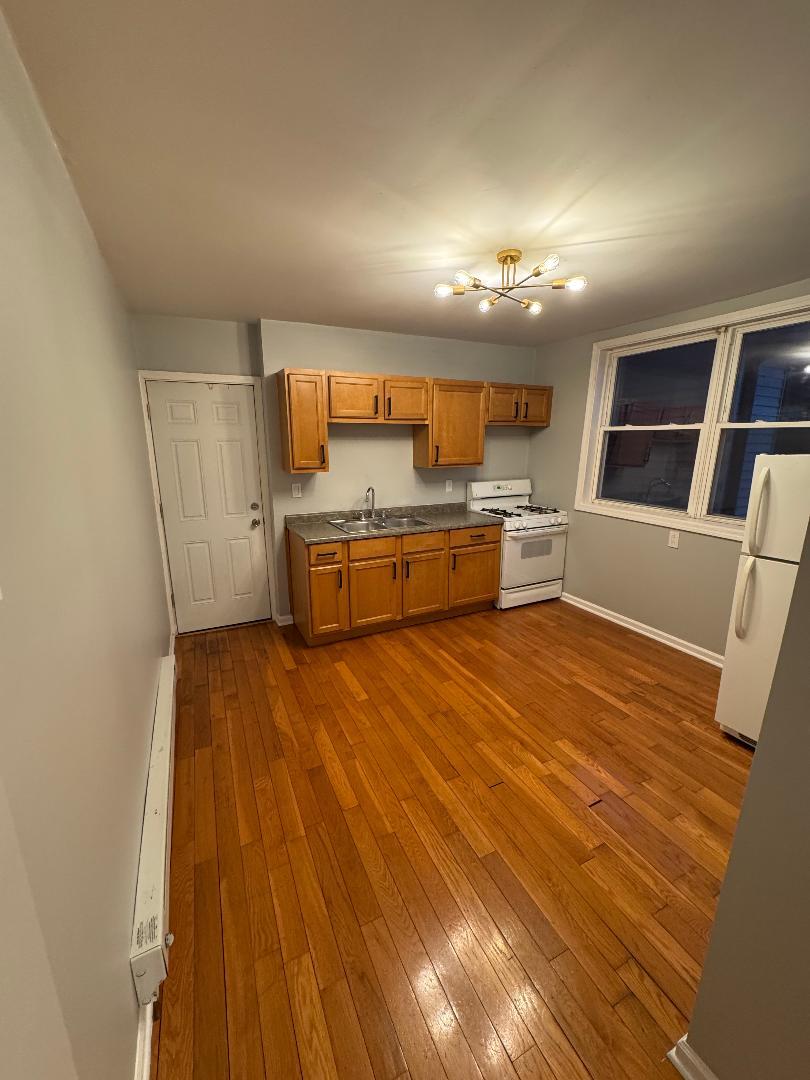 650 North Talman Avenue, Unit 1R Chicago, IL 60612 - Photo 3 of 5 a room with stainless steel appliances wooden floors and large window