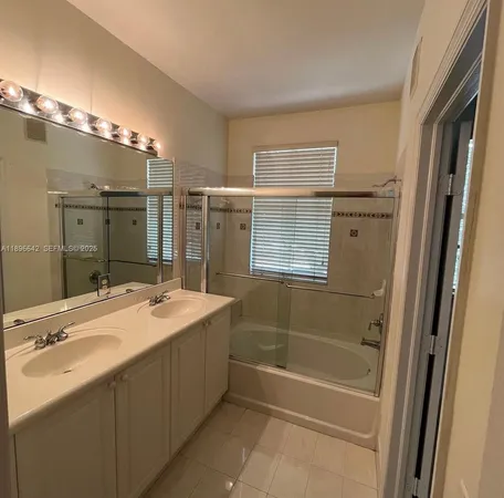 a bathroom with a tub sink shower and mirror