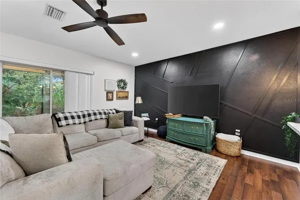 a kitchen with kitchen island granite countertop a stove a sink a refrigerator and white cabinets with wooden floor