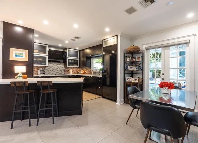 a kitchen with stainless steel appliances kitchen island granite countertop a table and chairs in it