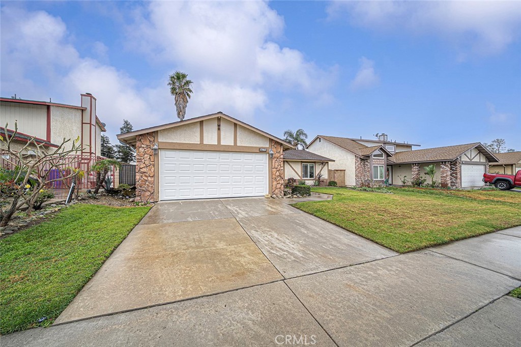 15465 Raymond Avenue Fontana, CA 92336 - Photo 17 of 27 a front view of a house with a yard and garage