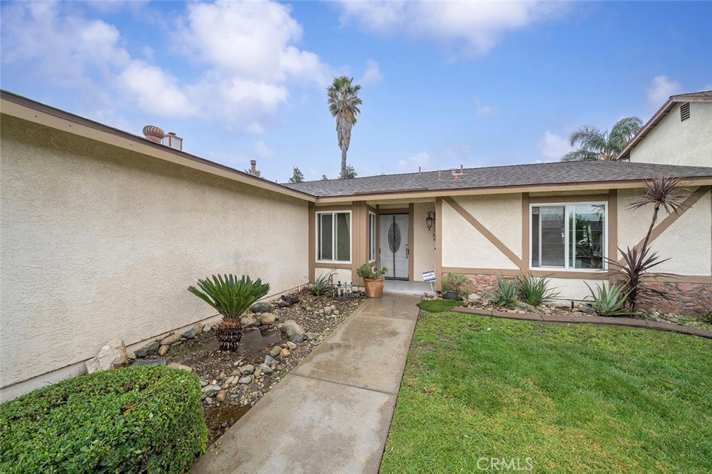 15465 Raymond Avenue Fontana, CA 92336 - Photo 20 of 27 a front view of a house with a garden and plants