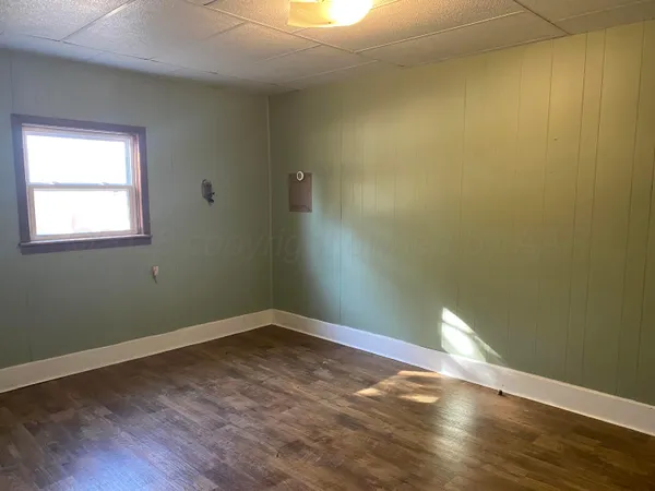 a view of a small space with wooden floor and a window