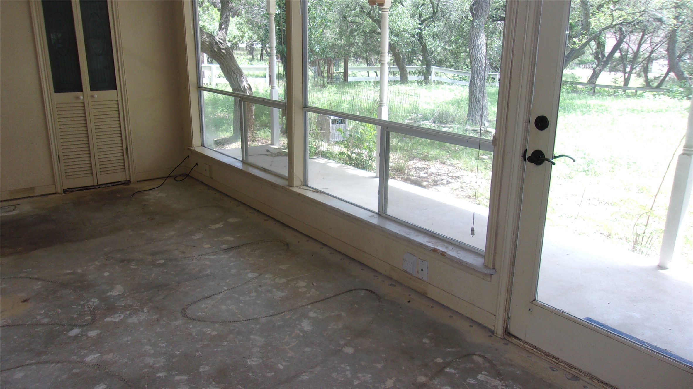702 Cottonwood Creek Road Dripping Springs, TX 78620 - Photo 18 of 31 Room featuring large windows, a sliding glass door, and a built-in louvered bi-fold closet