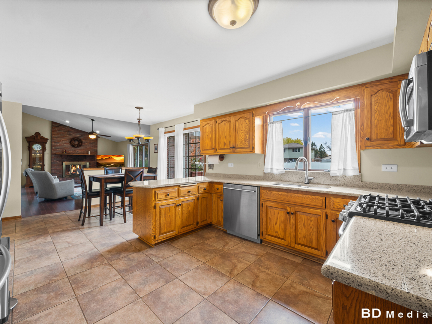1525 Cimarron Drive New Lenox, IL 60451 - Photo 12 of 41 a kitchen with stainless steel appliances granite countertop a stove top oven a sink a dining table and chairs with the large mirror