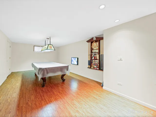 a view of a hallway with wooden floor and furniture