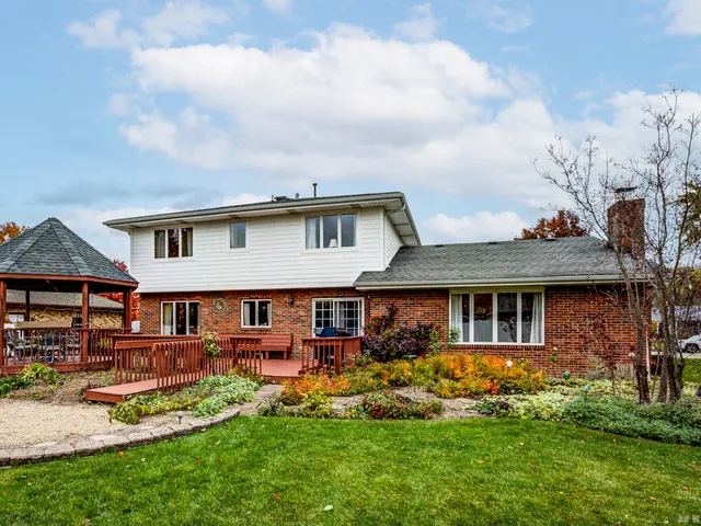 a front view of a residential houses with yard and green space