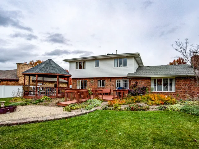 a front view of a house with garden and trees