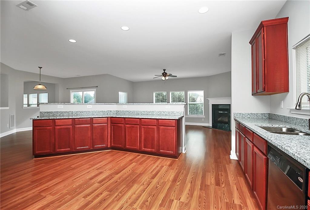 9522 Seamill Road Charlotte, NC 28278 - Photo 3 of 43 a kitchen with stainless steel appliances granite countertop a sink dishwasher stove and wooden floor