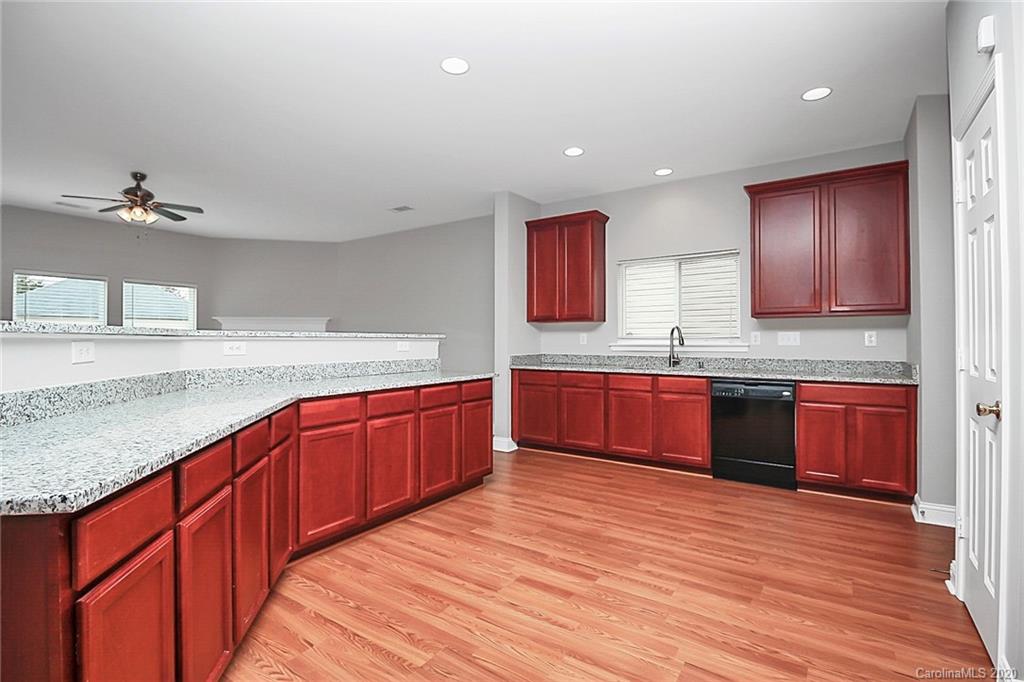 9522 Seamill Road Charlotte, NC 28278 - Photo 21 of 43 a kitchen with stainless steel appliances granite countertop wooden cabinets a sink and dishwasher with wooden floor
