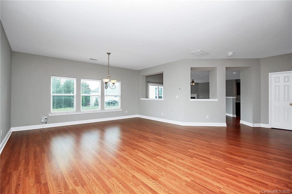 9522 Seamill Road Charlotte, NC 28278 - Photo 9 of 43 a view of an empty room with wooden floor and a window