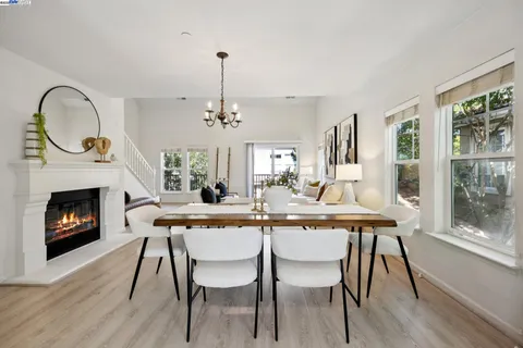 a dining room with furniture a fireplace and wooden floor