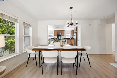 a dining room with furniture a chandelier and wooden floor