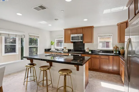 a kitchen with stainless steel appliances granite countertop sink stove and refrigerator