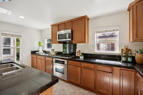 a kitchen with granite countertop cabinets a sink a window and stainless steel appliances