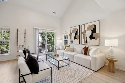 a living room with furniture and a large window with wooden floor