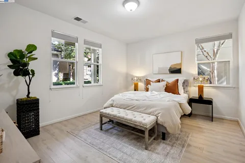 a bedroom with a bed a dresser and a window