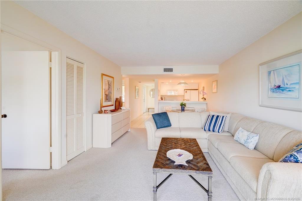 5593 Northeast Gulfstream Way Jensen Beach, FL 34957 - Photo 12 of 39 a living room with furniture a rug and a window
