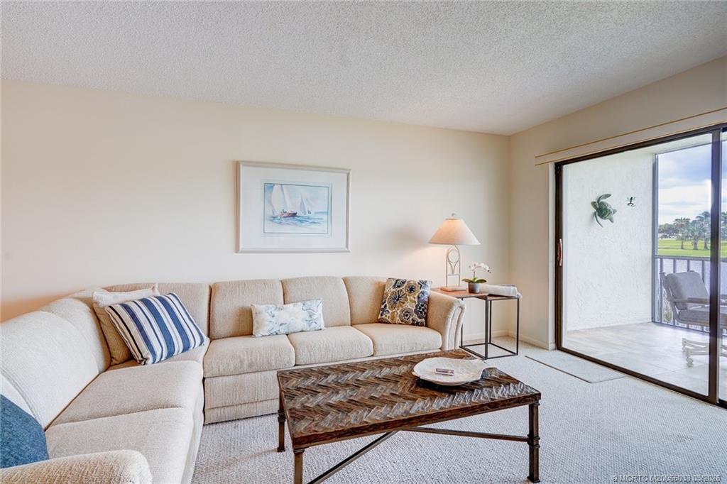 5593 Northeast Gulfstream Way Jensen Beach, FL 34957 - Photo 13 of 39 a living room with furniture and a lamp